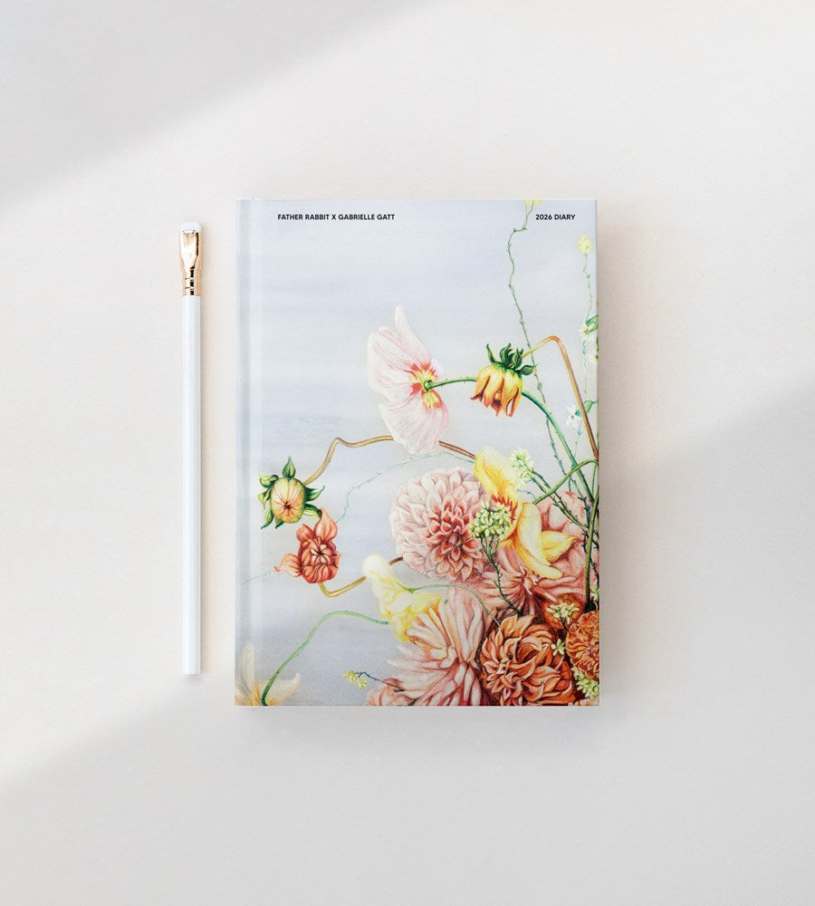 Floral notebook with a gold pen on a white background