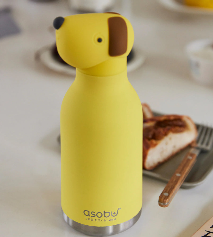 Yellow water bottle shaped like a dog on a kitchen counter with toast and a spatula.