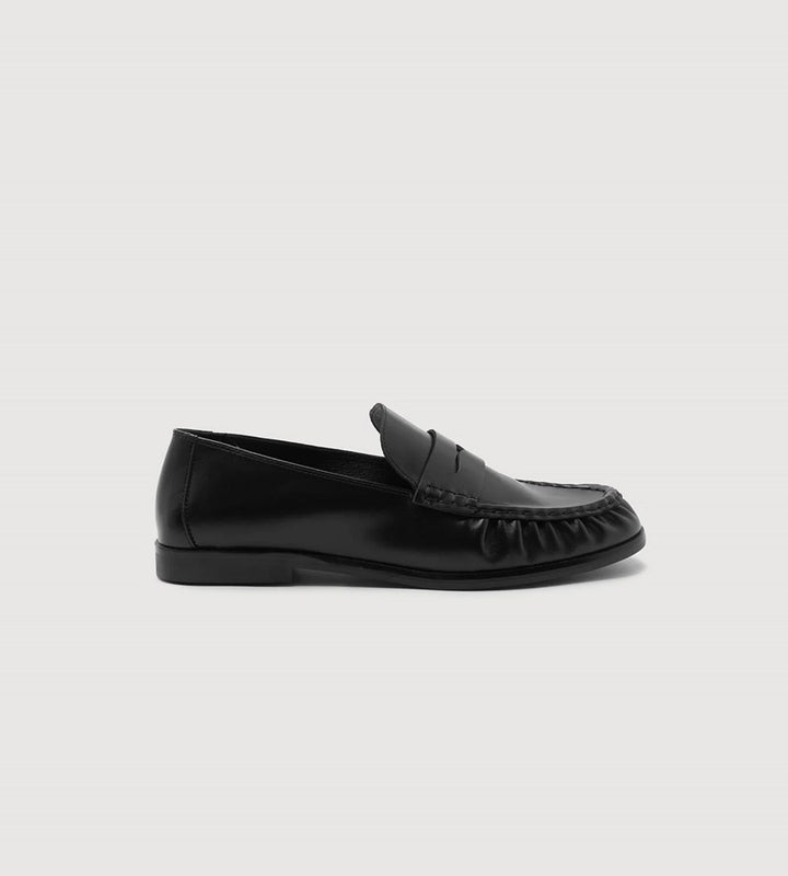 Black loafer shoe on a light gray background