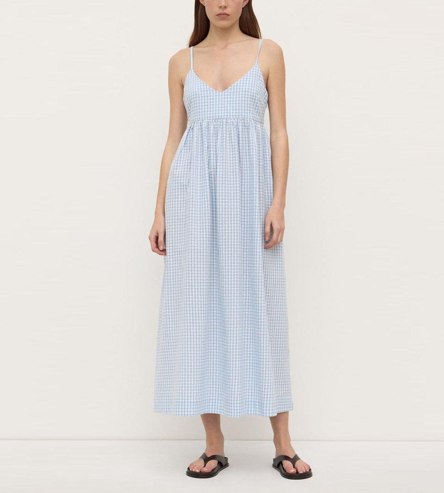 Woman wearing a light blue checkered dress on a white background