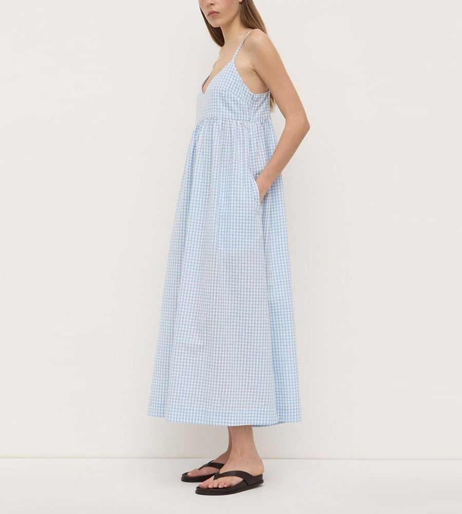 Woman wearing a blue checkered dress against a white background
