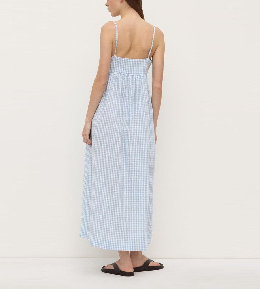 Woman wearing a blue checkered dress on a white background