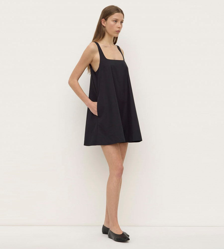 Woman wearing a black dress against a white background