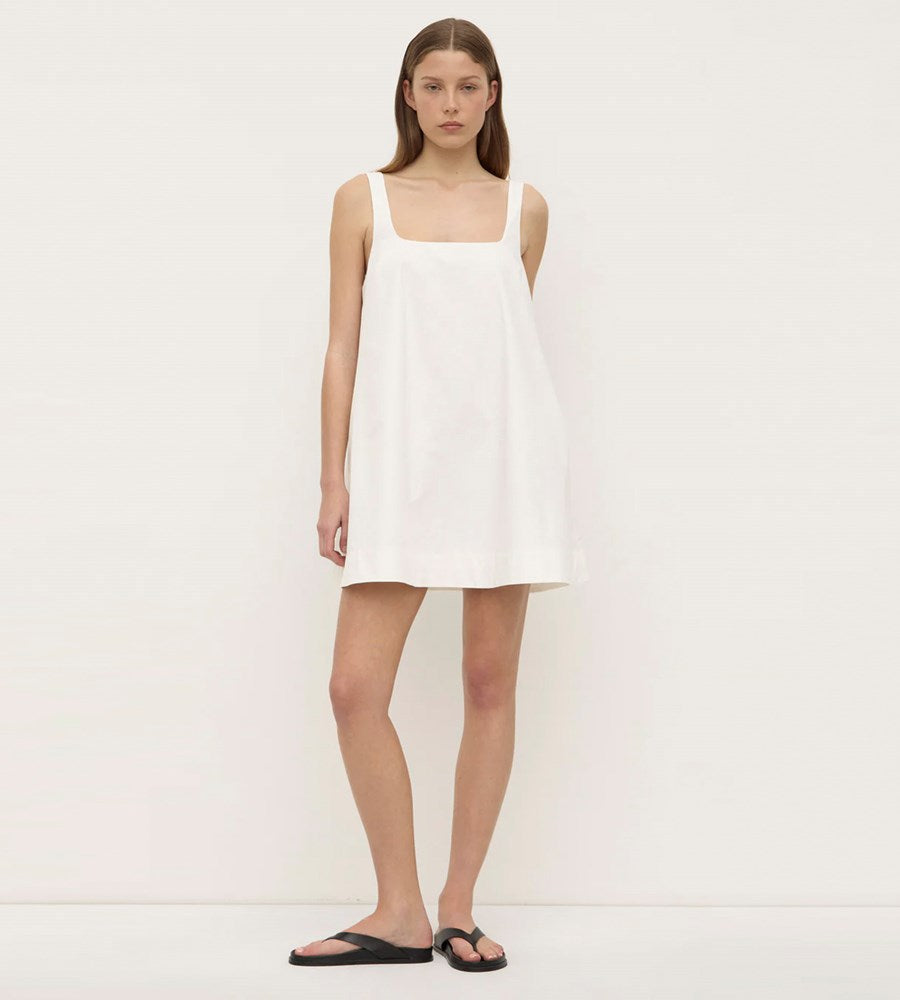 Woman wearing a white dress against a plain background