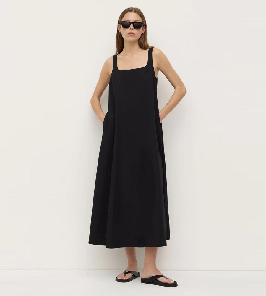 Woman wearing a black sleeveless dress against a white background