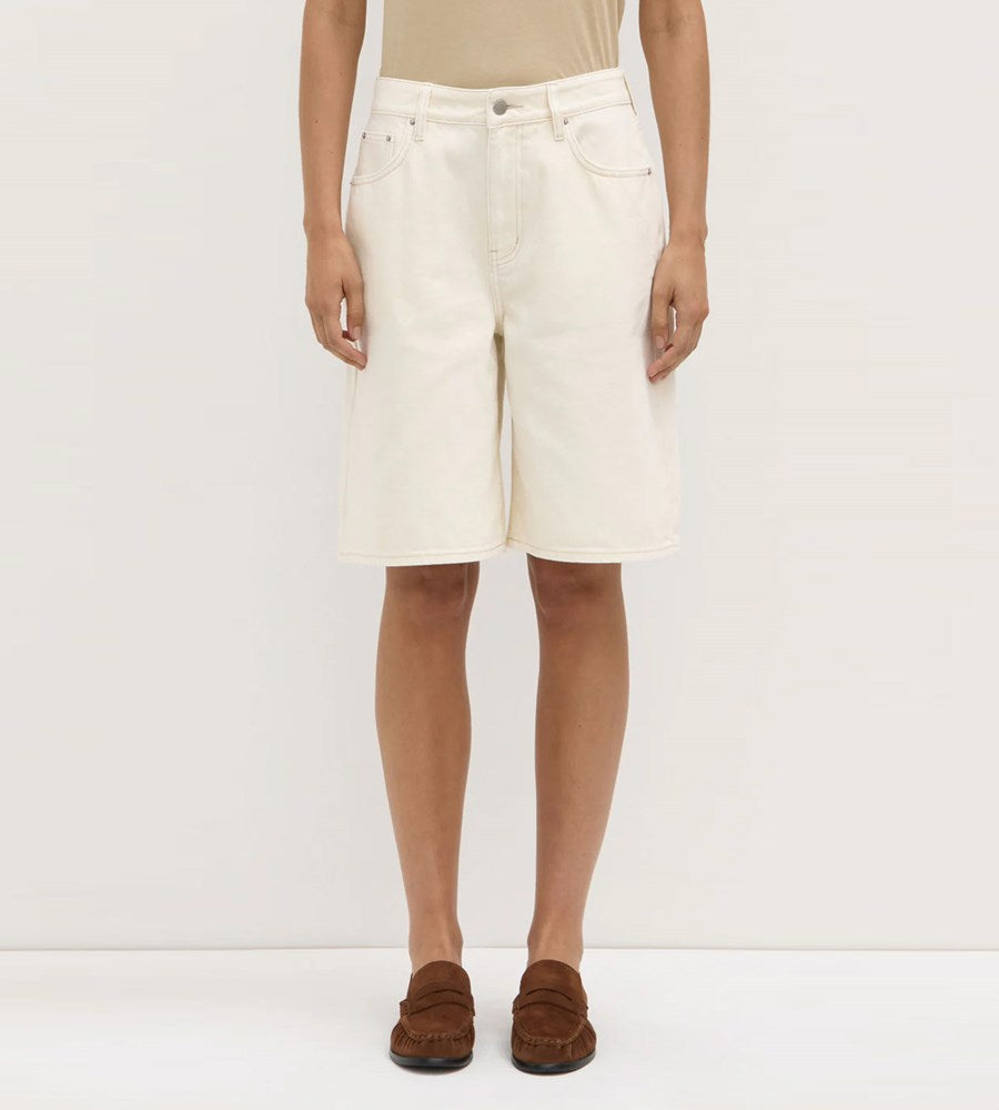 Person wearing a white denim skirt on a white background