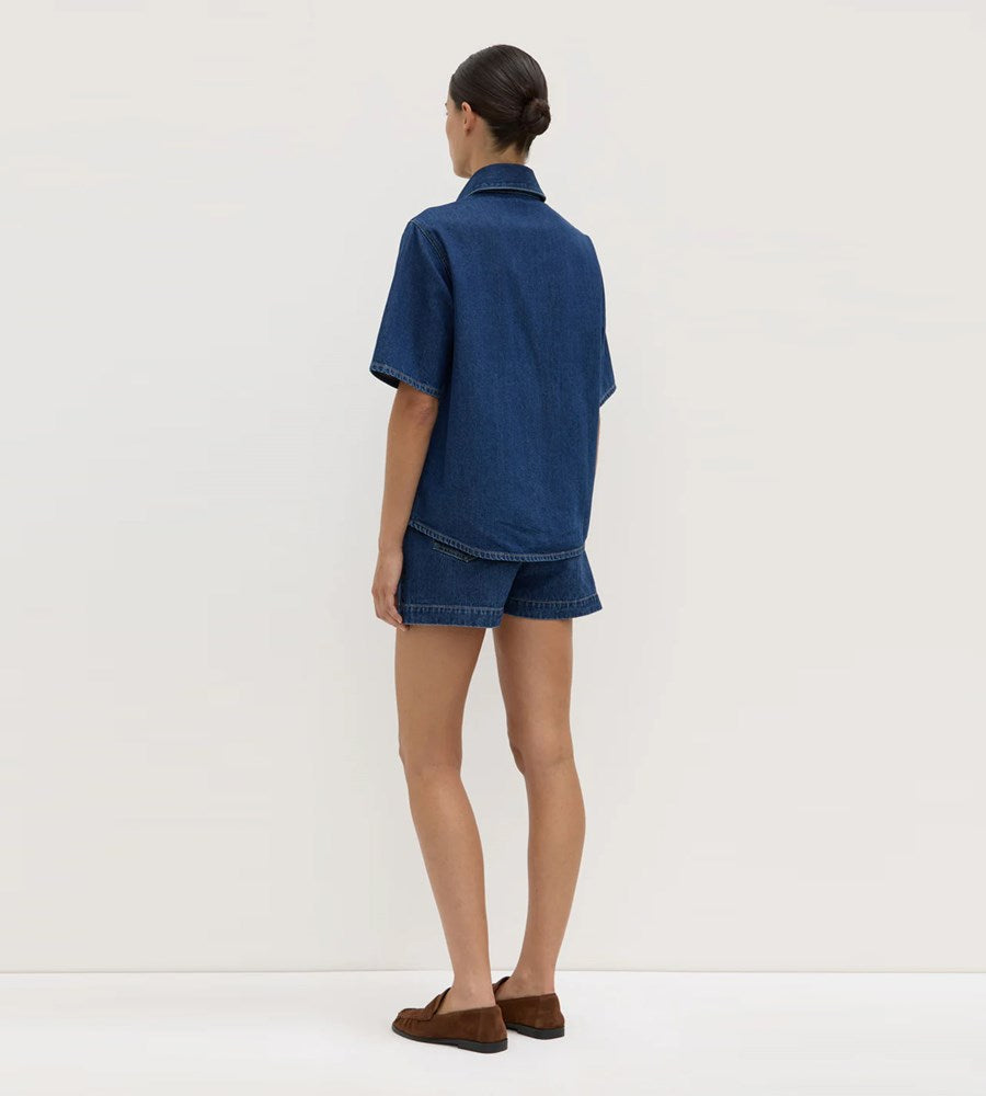 Person wearing a blue denim outfit on a white background