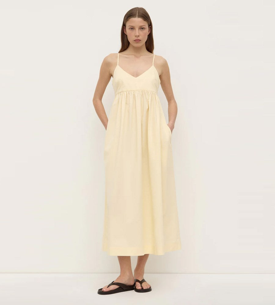 Woman wearing a light yellow dress against a white background
