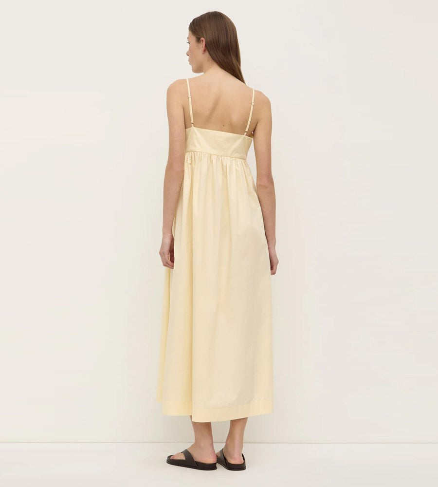 Woman wearing a light yellow dress against a white background