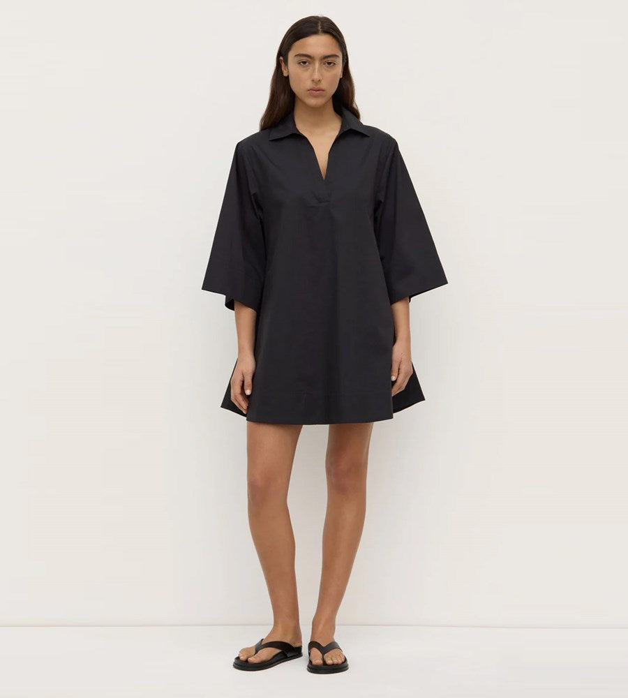 Woman wearing a black dress against a white background