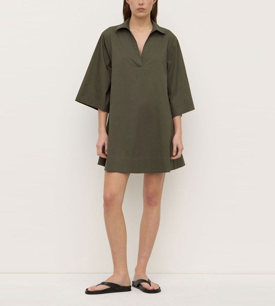 Person wearing a green dress against a white background