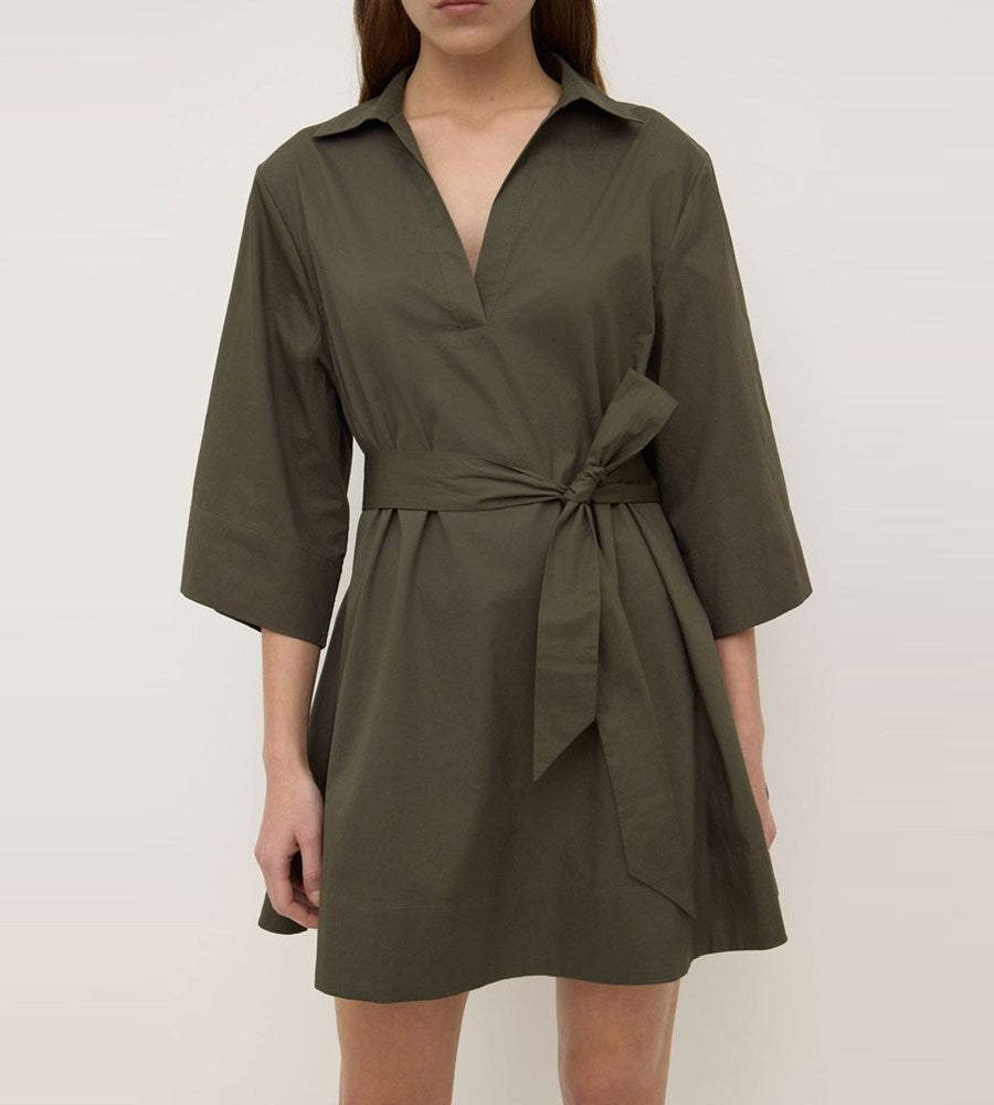 Green dress with a belt worn by a person on a white background