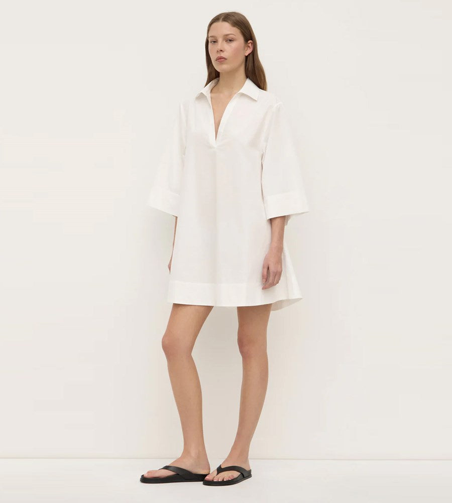 Woman wearing a white dress against a plain background