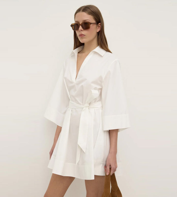 Woman wearing a white dress with a plain background