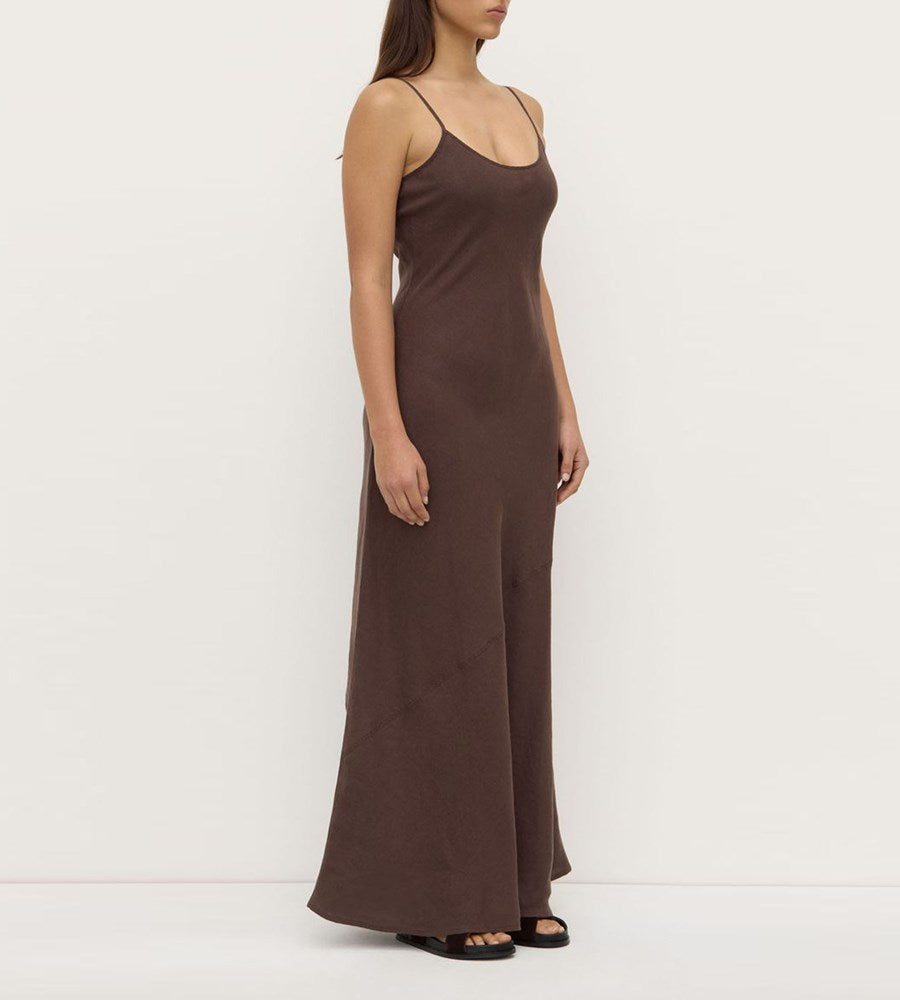 Woman wearing a brown slip dress against a white background