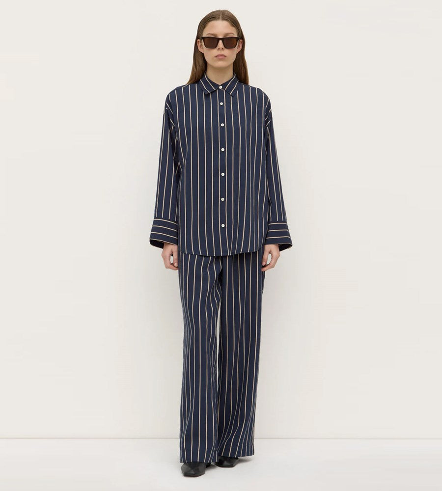 Person wearing a navy and white striped outfit on a white background