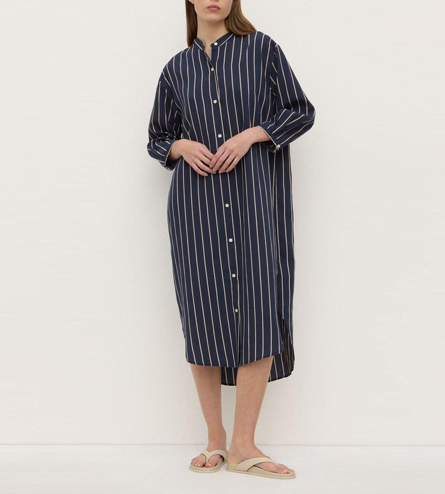 Person wearing a navy and white striped dress against a white background
