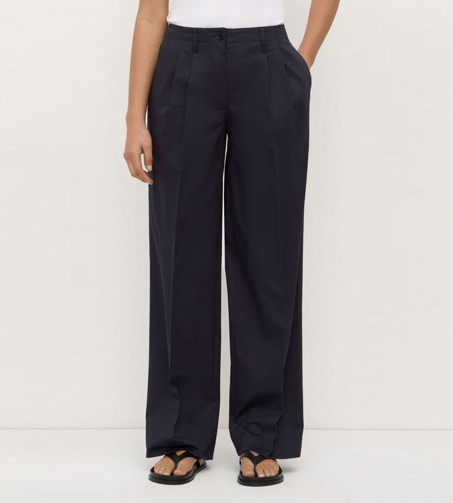 Person wearing navy wide-leg pants on a white background