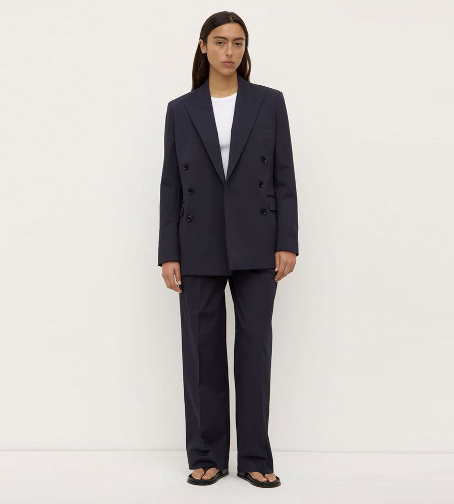 Person wearing a navy suit with a white shirt on a white background