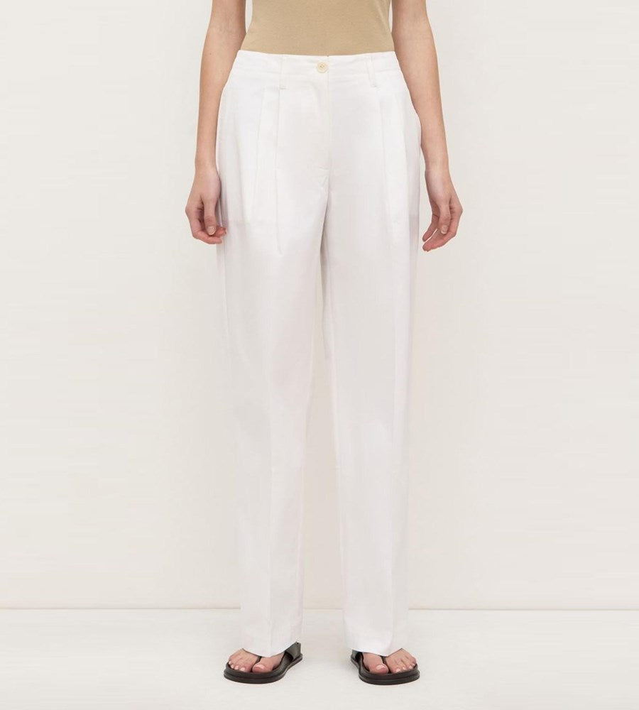Person wearing white pants on a plain background