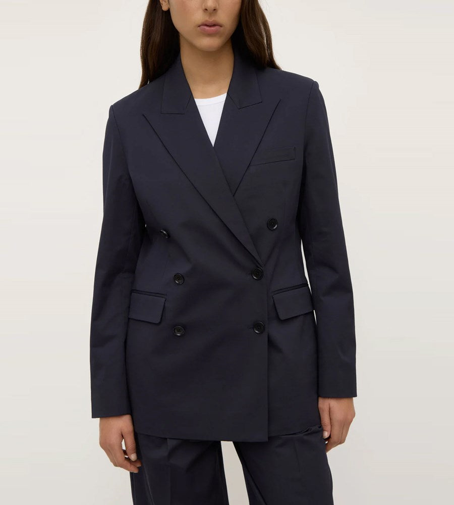 Navy blue blazer worn by a person on a white background
