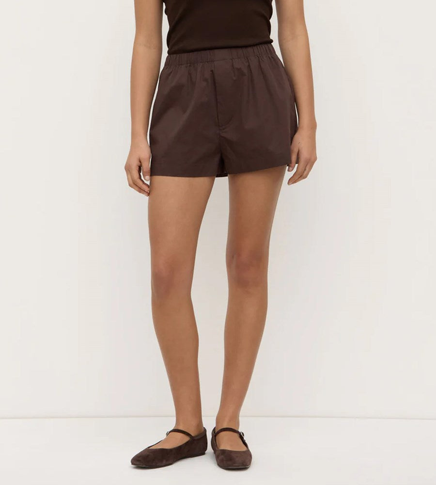 Person wearing brown shorts on a white background