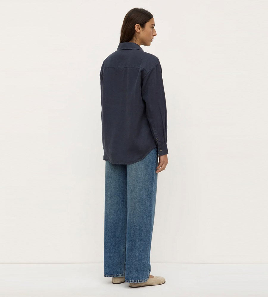 Person wearing a dark blue shirt and jeans on a white background