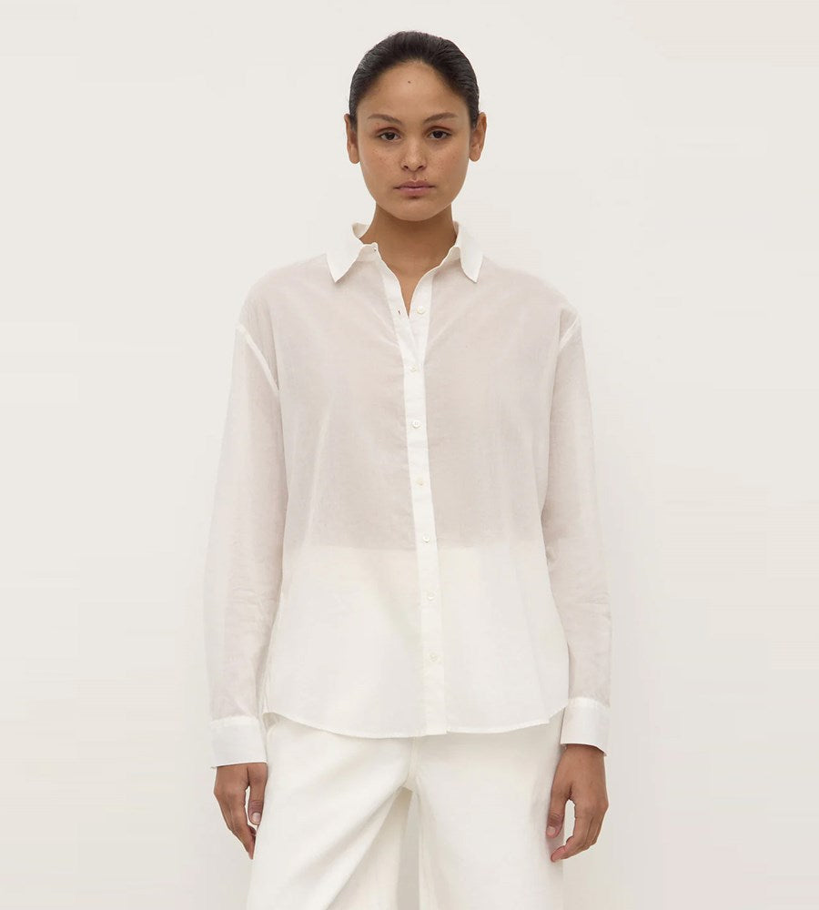 Person wearing a white shirt and pants on a plain background