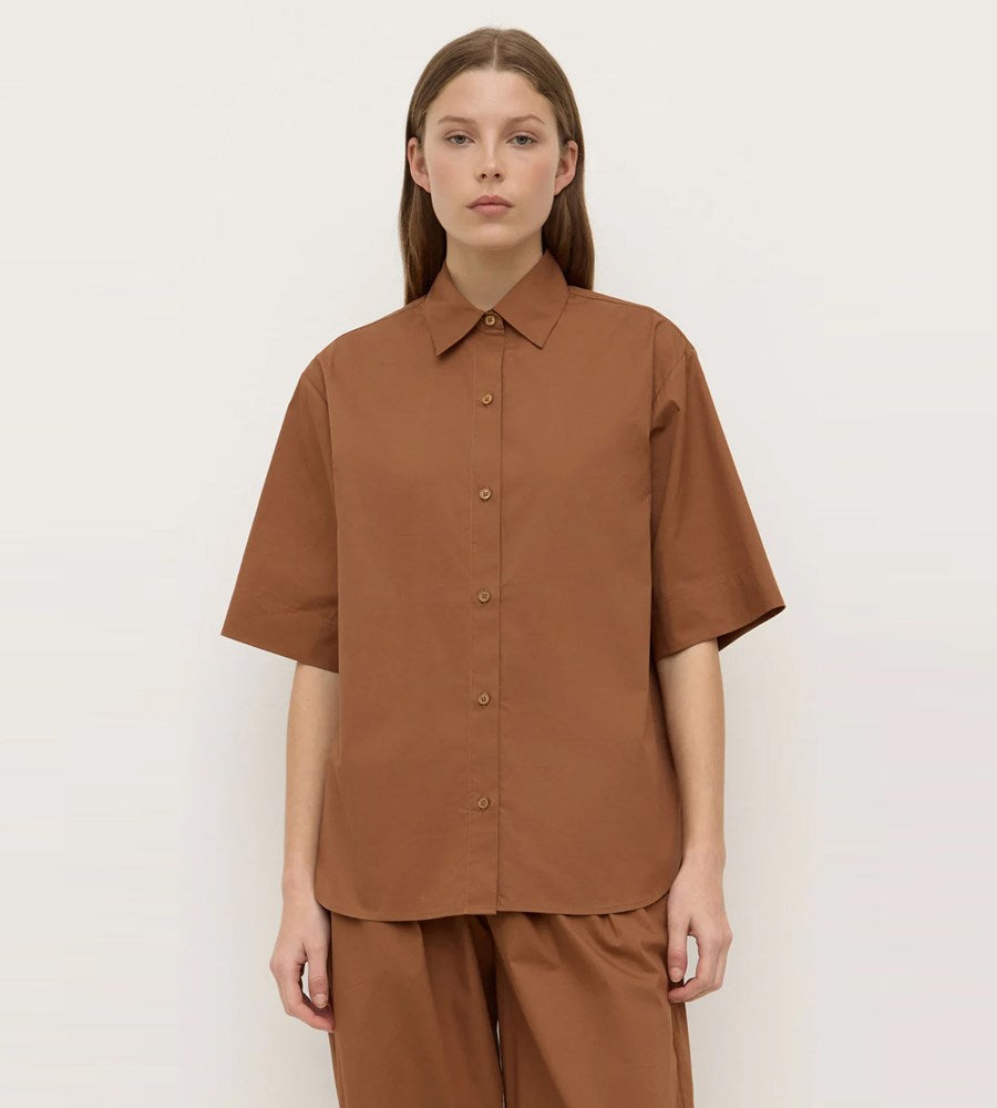 Woman wearing a brown shirt and pants on a white background