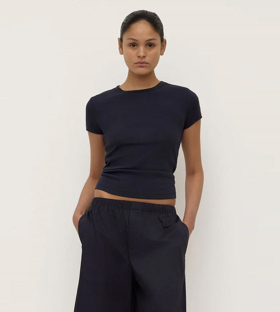 Person wearing a black t-shirt and pants against a white background