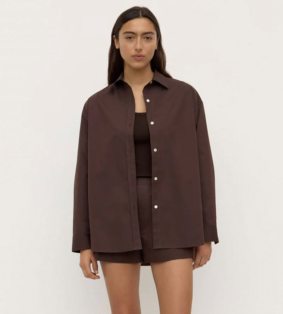 Woman wearing a brown jacket and shorts on a white background