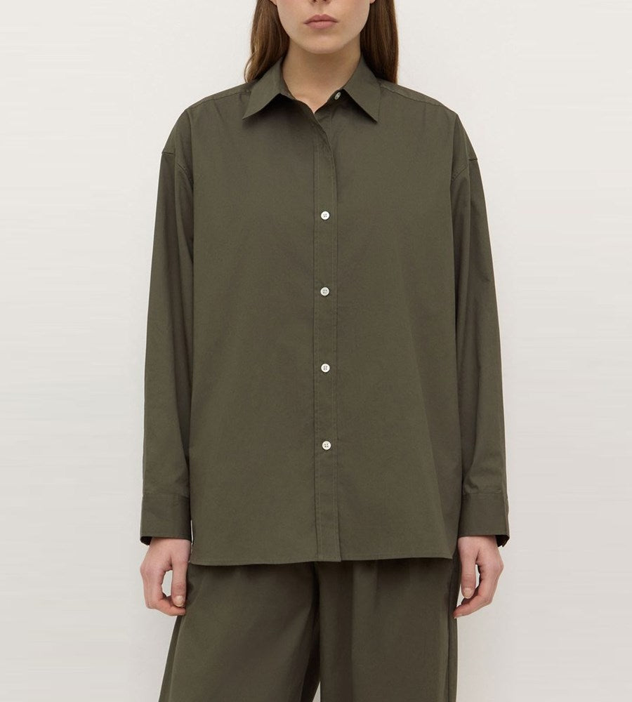 Person wearing an olive green shirt and pants on a plain background