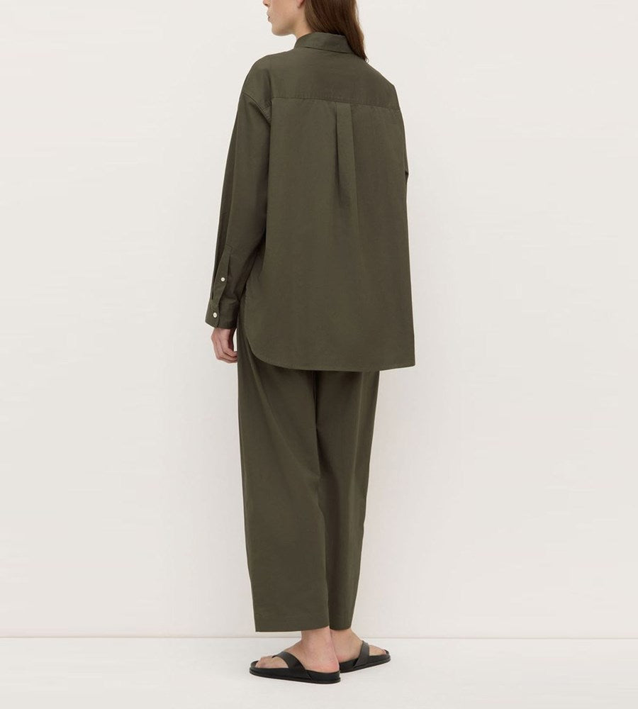Person wearing a green outfit against a white background