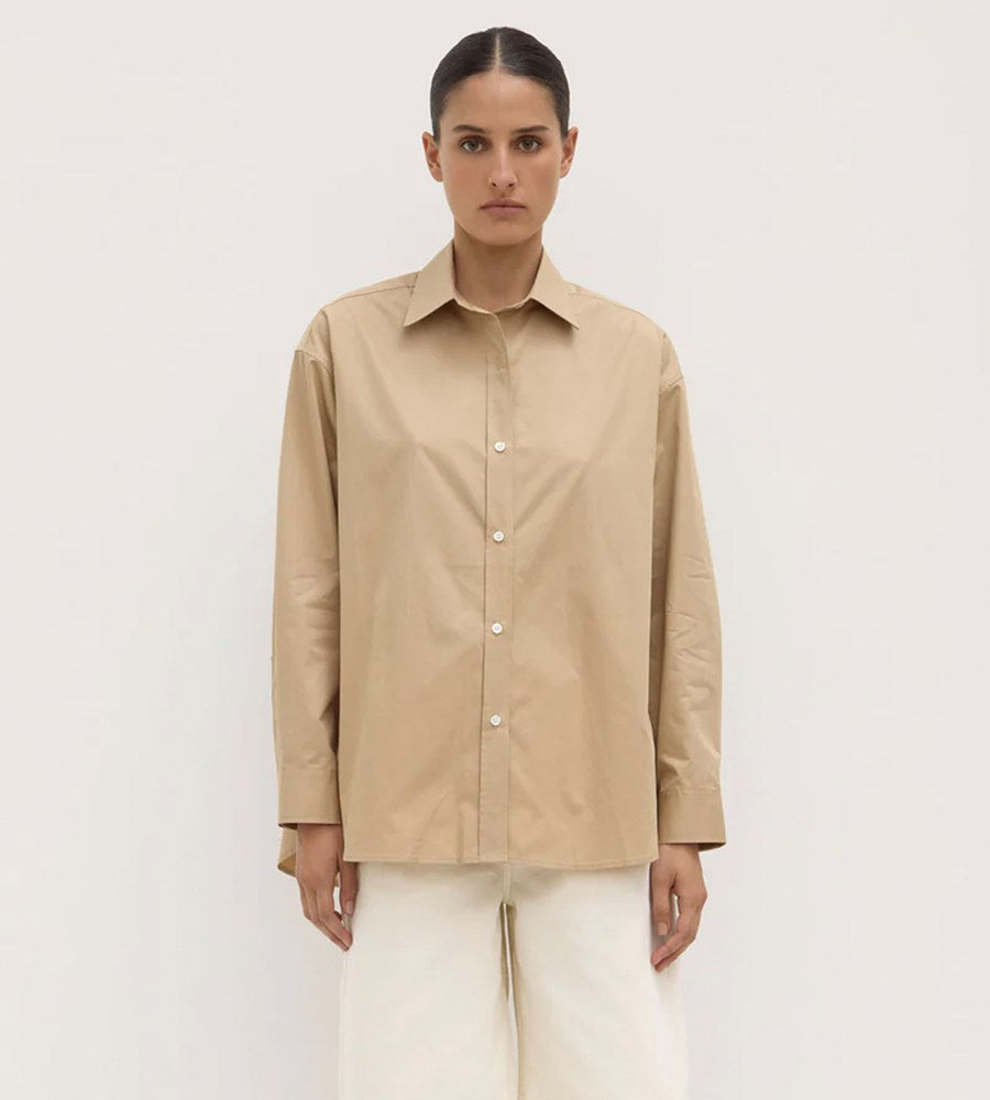 Woman wearing a beige shirt against a white background
