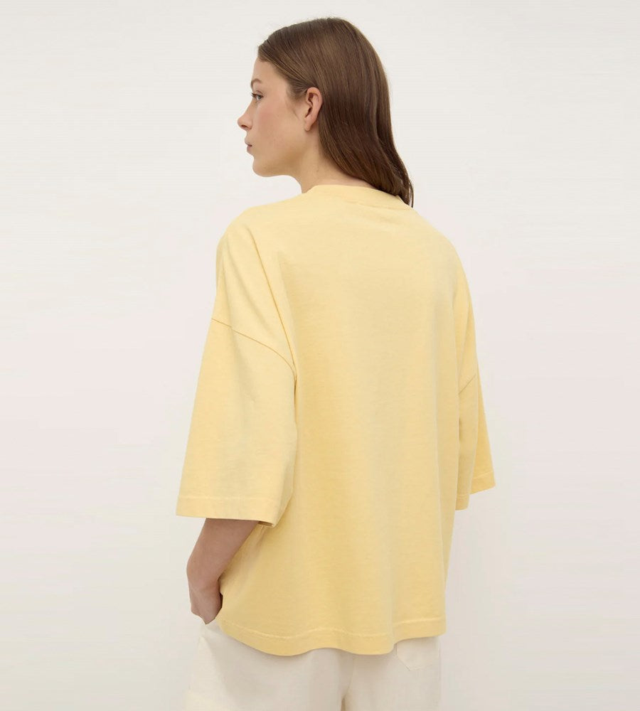 Woman wearing a yellow top against a white background