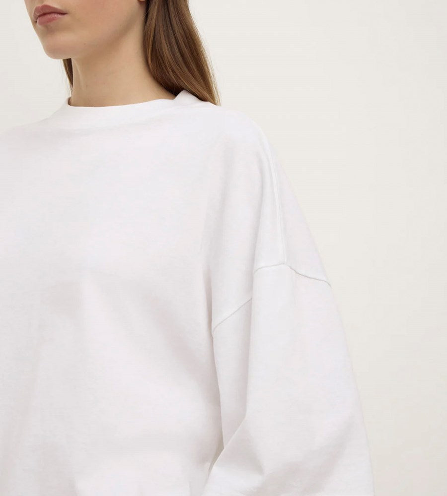 White sweatshirt worn by a person on a plain background