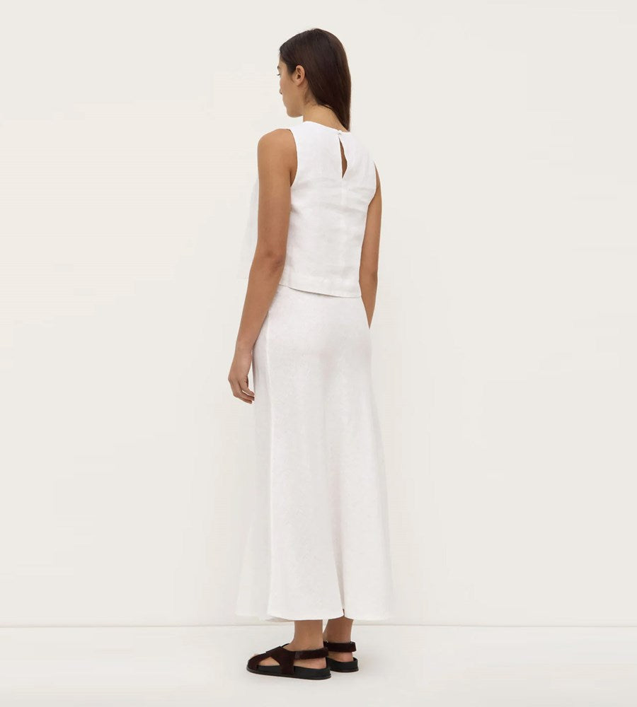 Woman wearing a white sleeveless top and wide-leg pants on a white background