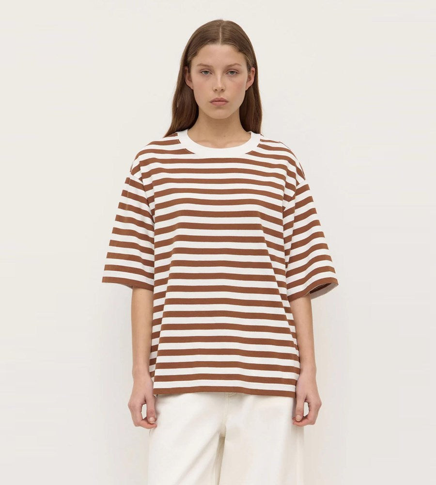 Woman wearing a brown and white striped shirt on a plain background