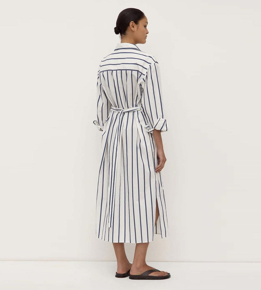 Woman wearing a black and white striped dress against a white background