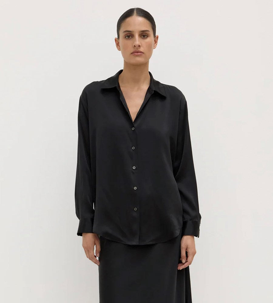 Person wearing a black shirt on a plain background