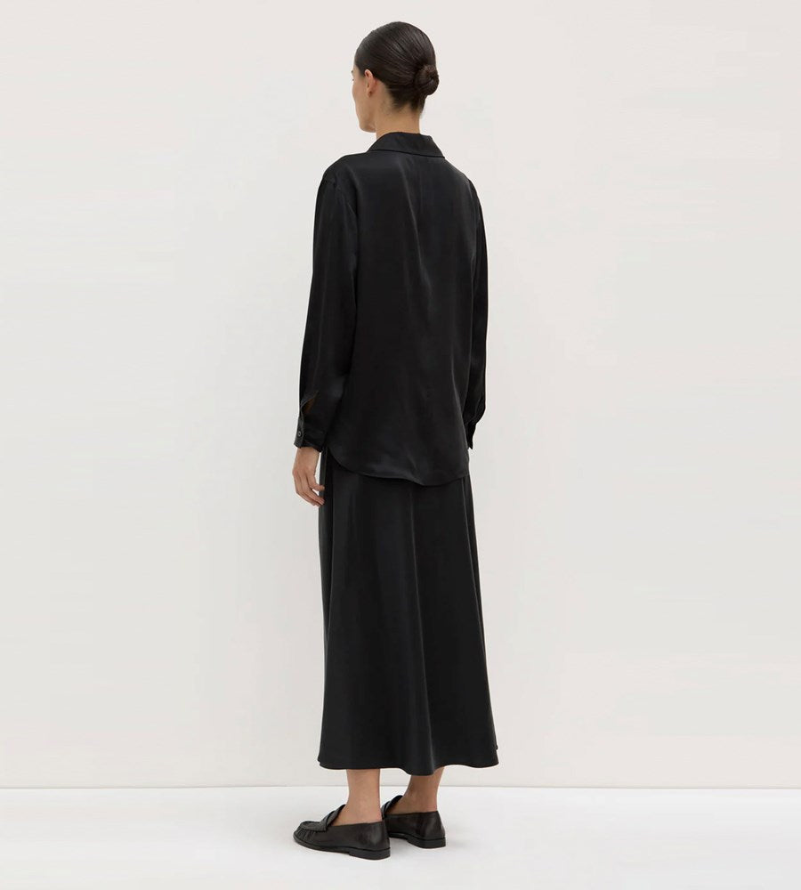 Person wearing a black outfit against a white background