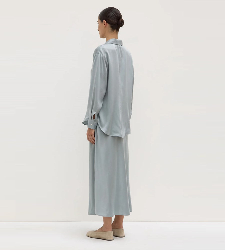 Person wearing a light gray outfit on a white background