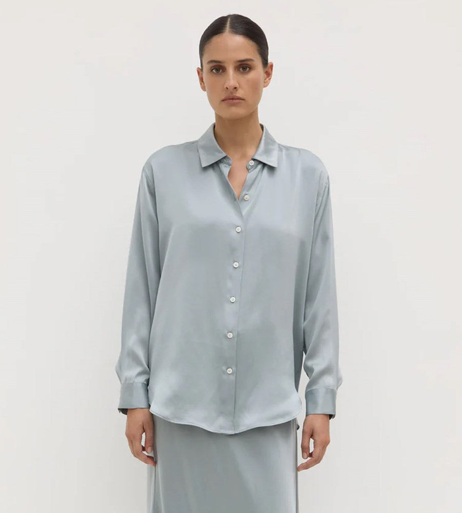 Woman wearing a light blue shirt against a white background