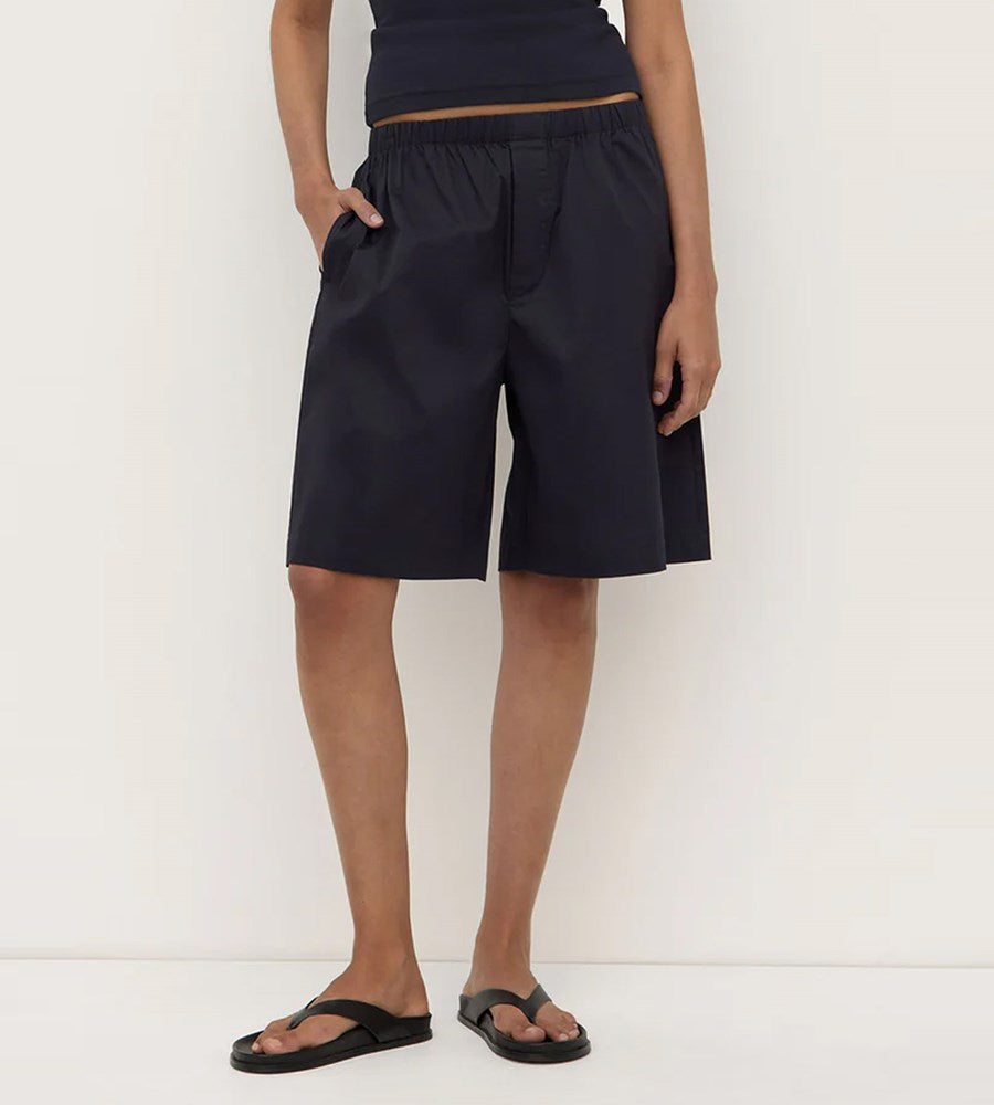 Person wearing black shorts on a white background