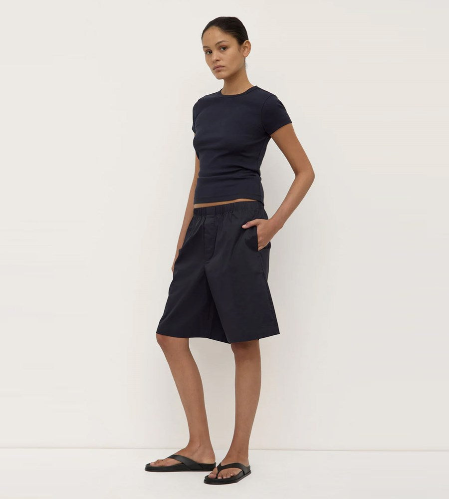 Woman wearing a black top and skirt on a white background