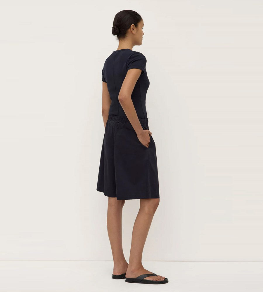 Woman wearing a black dress against a white background