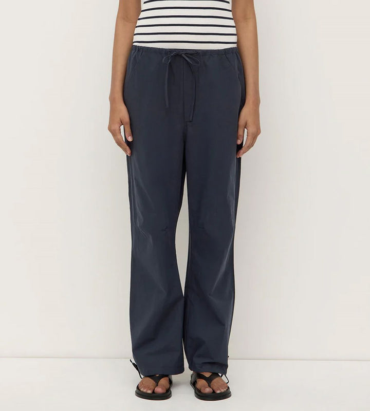 Person wearing navy pants and a striped shirt on a white background