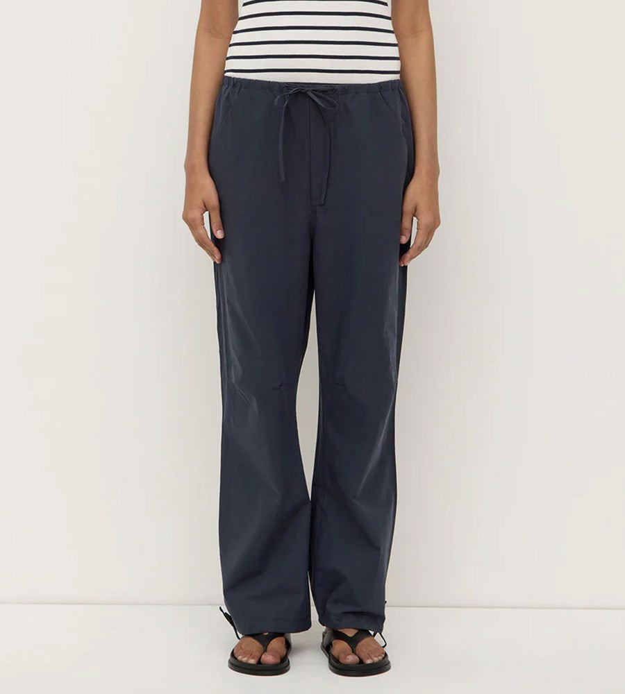 Person wearing navy pants and a striped shirt on a white background