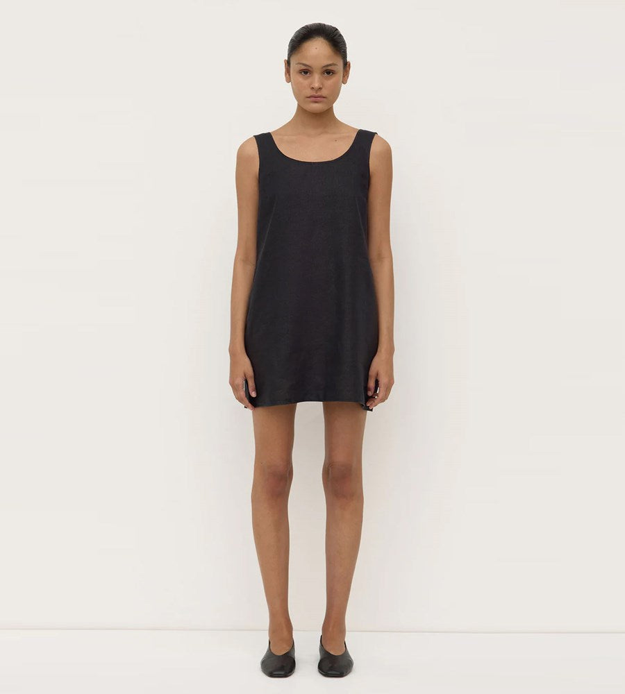 Woman wearing a black sleeveless dress against a white background