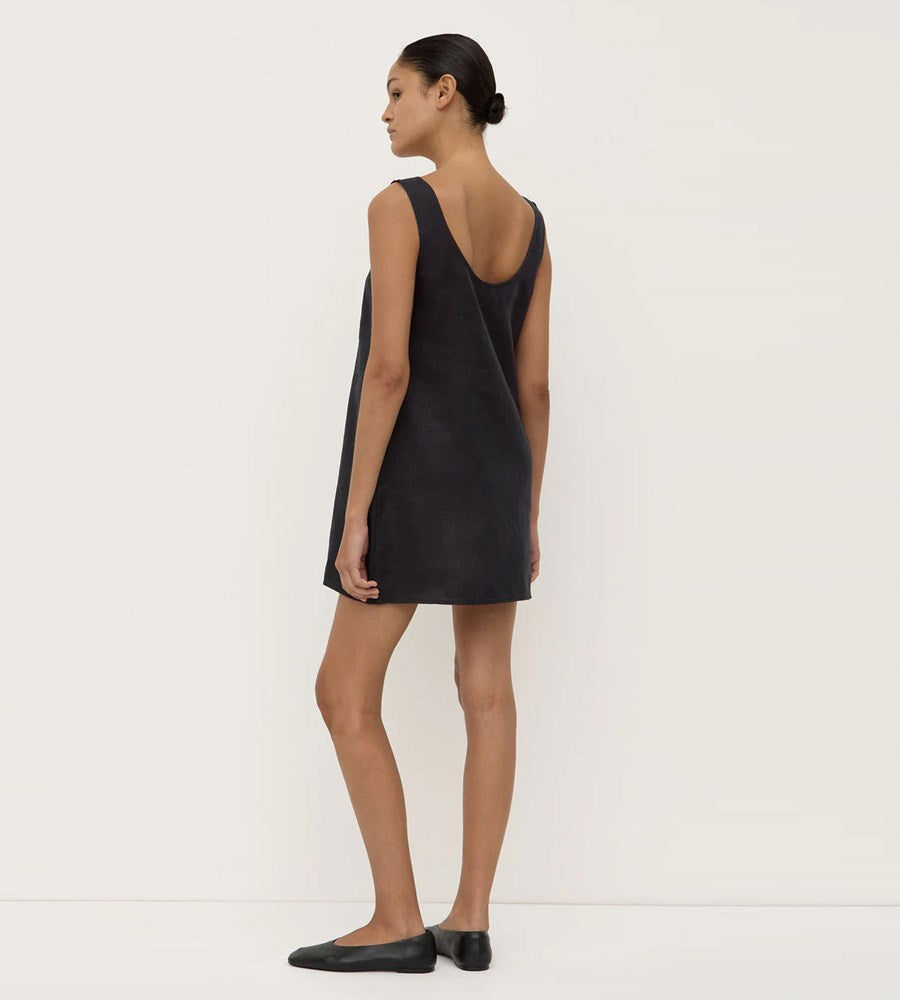 Woman wearing a black sleeveless dress against a white background